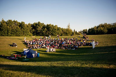 An audience enjoying Alice in Wonderland in a Saskatoon city park