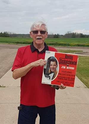 Jim Munro with his album, Roving Saskatchewan