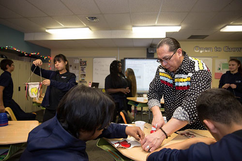Artist Lorne Kequahtooway helps students with their Buffalo projects