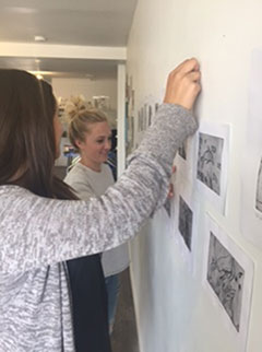 Students hang artwork at their exhibition at Void Gallery