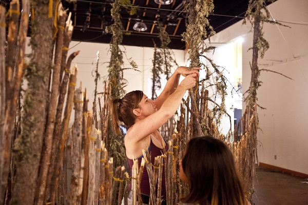 Michèle Mackasey installing the exhibition, Axenet'i Tth'al, at Wanuskewin Heritage Park in 2017