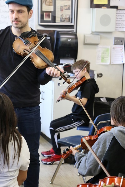 Karrnnel Sawitsky teaches students at St. Michael Community School the fiddle