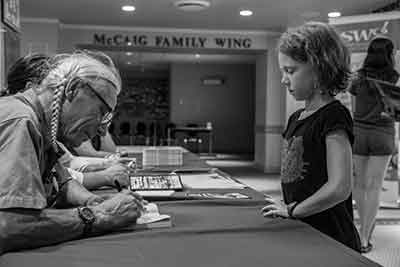 Harold Johnson signs a copy of Firewater for a young fan at the Saskatchewan Festival of Words