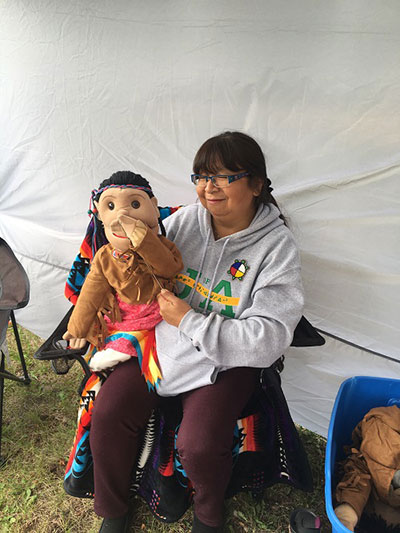 A participant learns puppetry at the camp