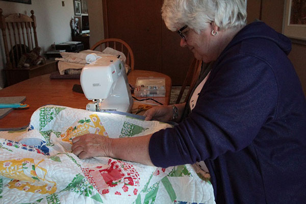 Sandra Dixon sewing a colorful quilt