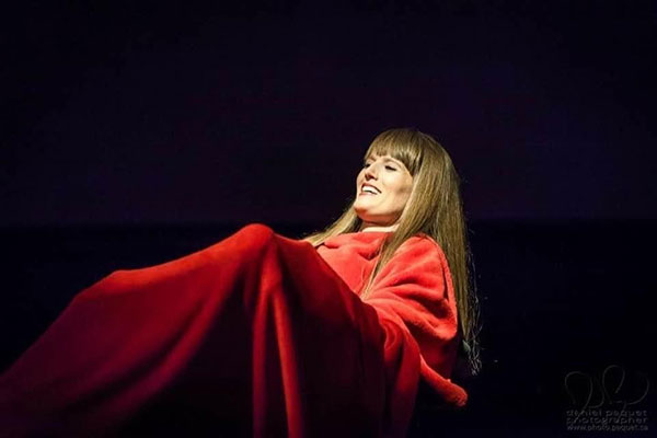 Natasha Urkow covered in a red blanket during one of her performances with Listen to Dis'
