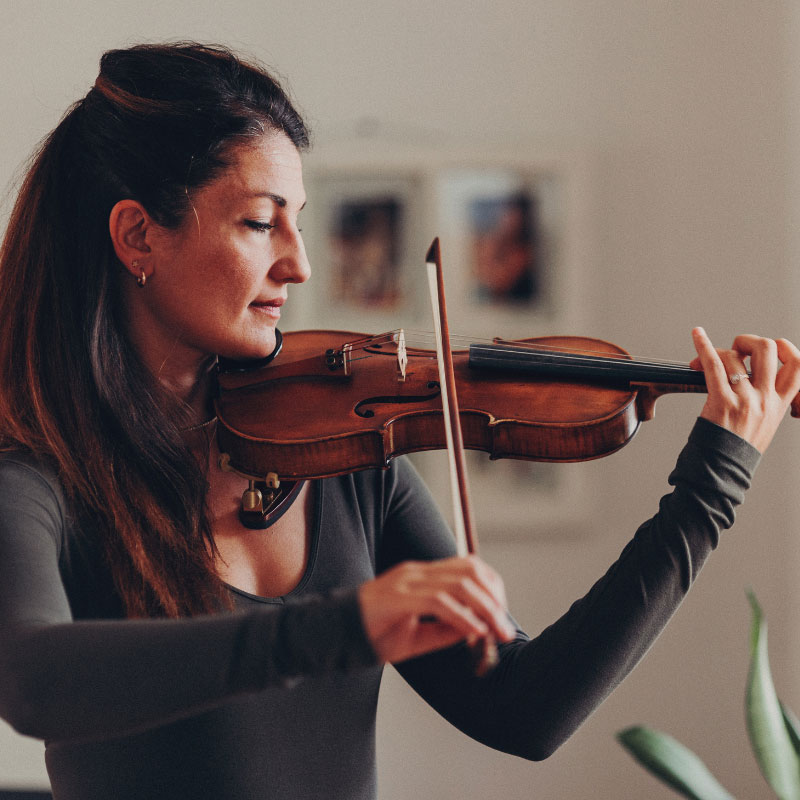 Karley Parovski - Woman with long brown hair in half up half down style playing a violin