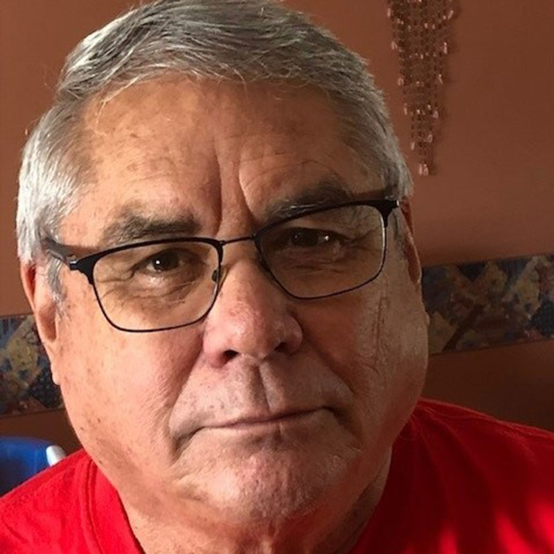 Doug Cuthand - Close up picture of older man wearing glasses and a red t-shirt