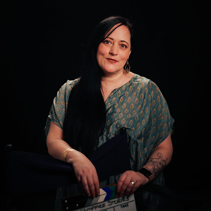 Allia Janzen - Portrait of indigenous woman with long black hair holding a film clapboard